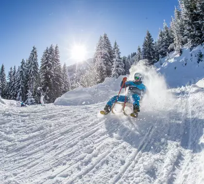 Rodler auf Rodelbahn in winterlicher Landschaft