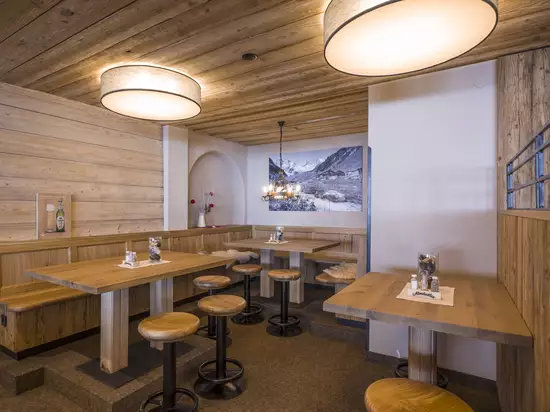 Gemütlicher Gastraum im Tiroler Stil mit Holzvertäfelung und traditionellen Einrichtungselementen