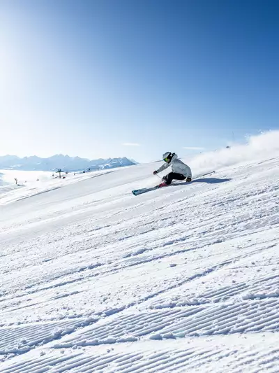 Skifahrer auf Piste blauer Himmel