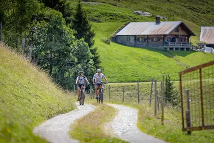 Zwei Radfahrer auf einem Almweg