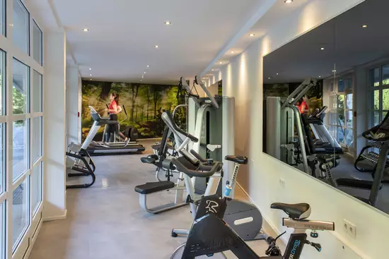 Fitnessraum mit großem Spiegel und Cardio Geräten im Berghotel Hochfügen