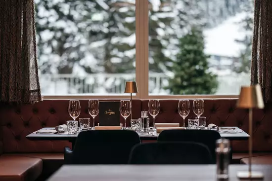 Modernes Tischsetting mit Aussicht auf die verschneiten Berge
