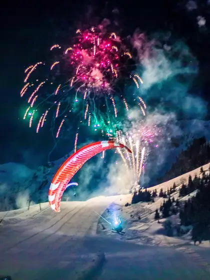 Feuerwerk im Winter vor beleuchteten Schneeberg