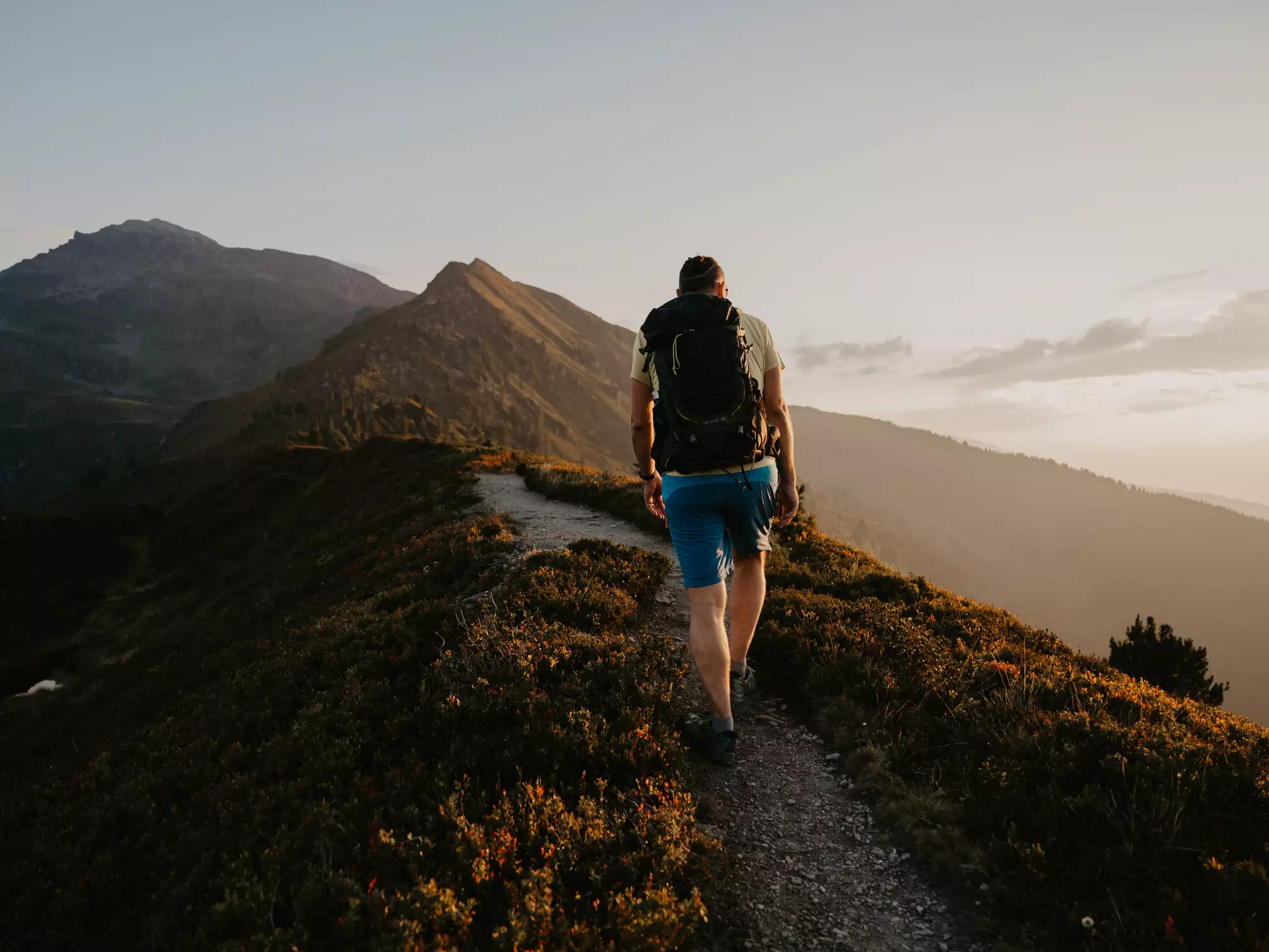 Person auf einem Wanderweg in traumhafter Berglandschaft