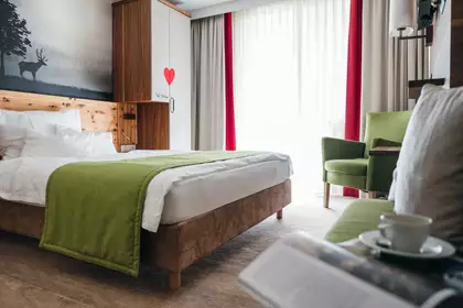 Helles Zimmer mit großen Fenstern und grünen Akzenten