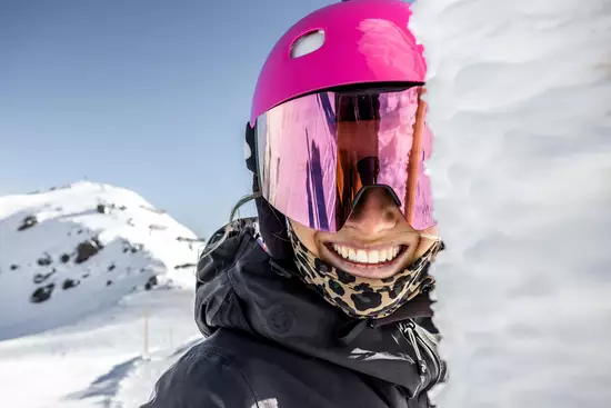Frau mit pinken Helm in Skigebiet Nahaufnahme