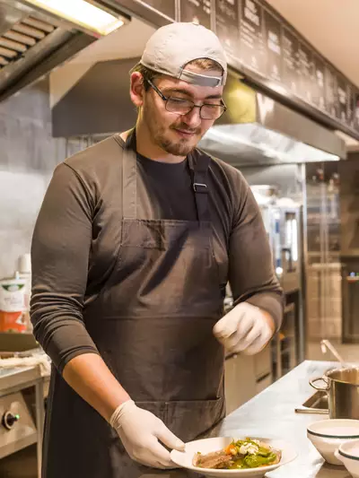 Kochteam, das in der Restaurantküche Gerichte vorbereitet