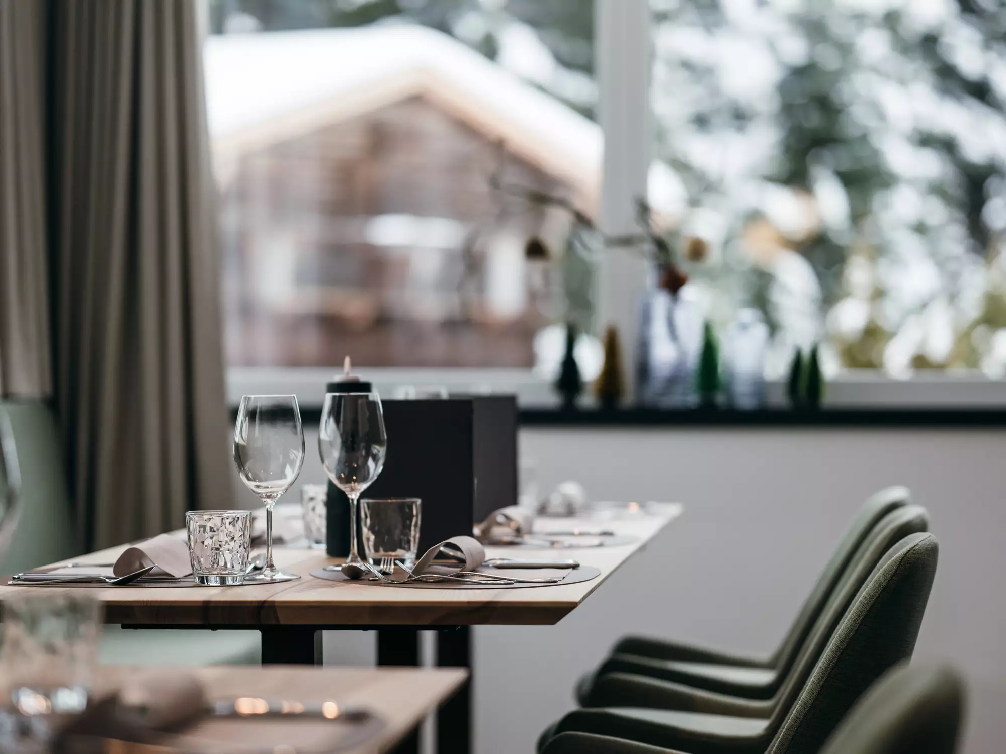 Modernes Tischsetting mit Aussicht auf verschneite Landschaft