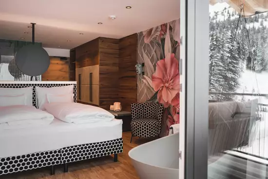 Design Suite mit Glasfront, Blick auf die Berge und moderner Inneneinrichtung