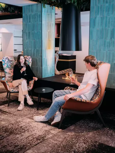 Pärchen mit Drinks in gemütlicher Sitzecke