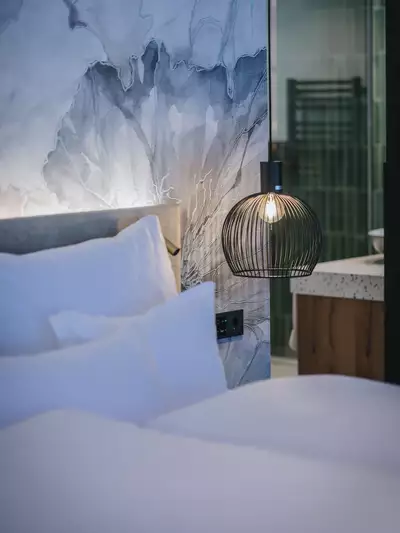 Gemütliches Doppelbett in geräumiger Suite