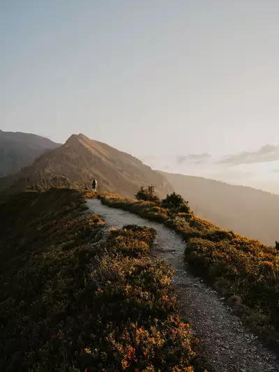 Stimmungsvolle Wanderung bei Sonnenuntergang mit Blick auf die Berge